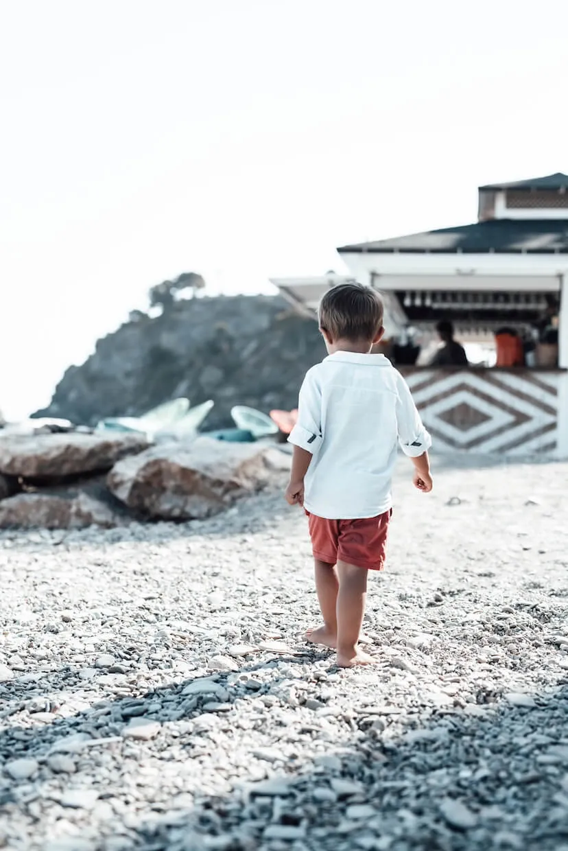 Kind am Strand vor einer Strandbar